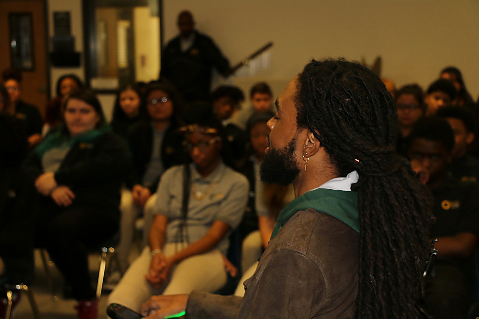 Que Crane speaking closely with a room of students