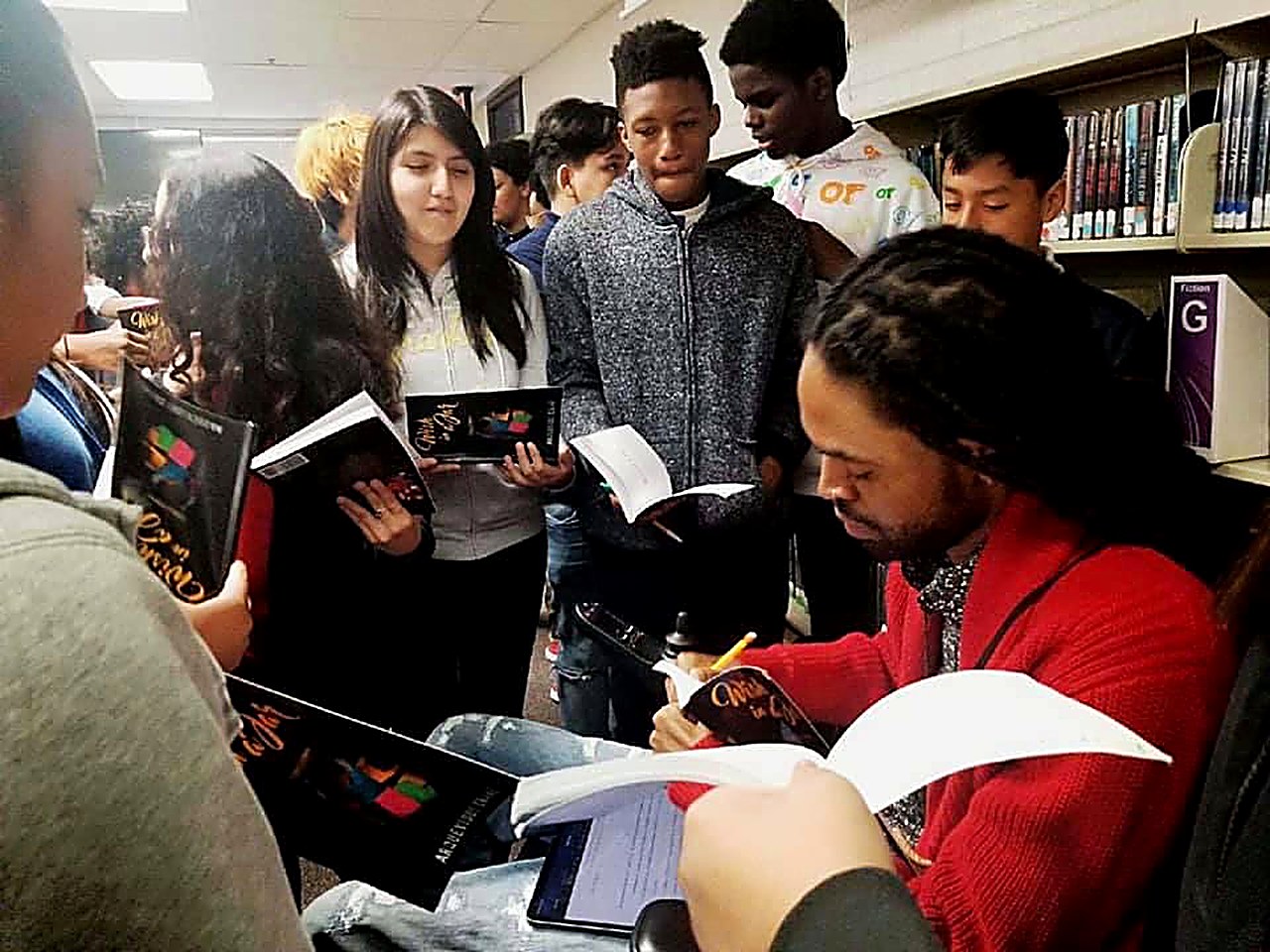 Que Crane signing books for students