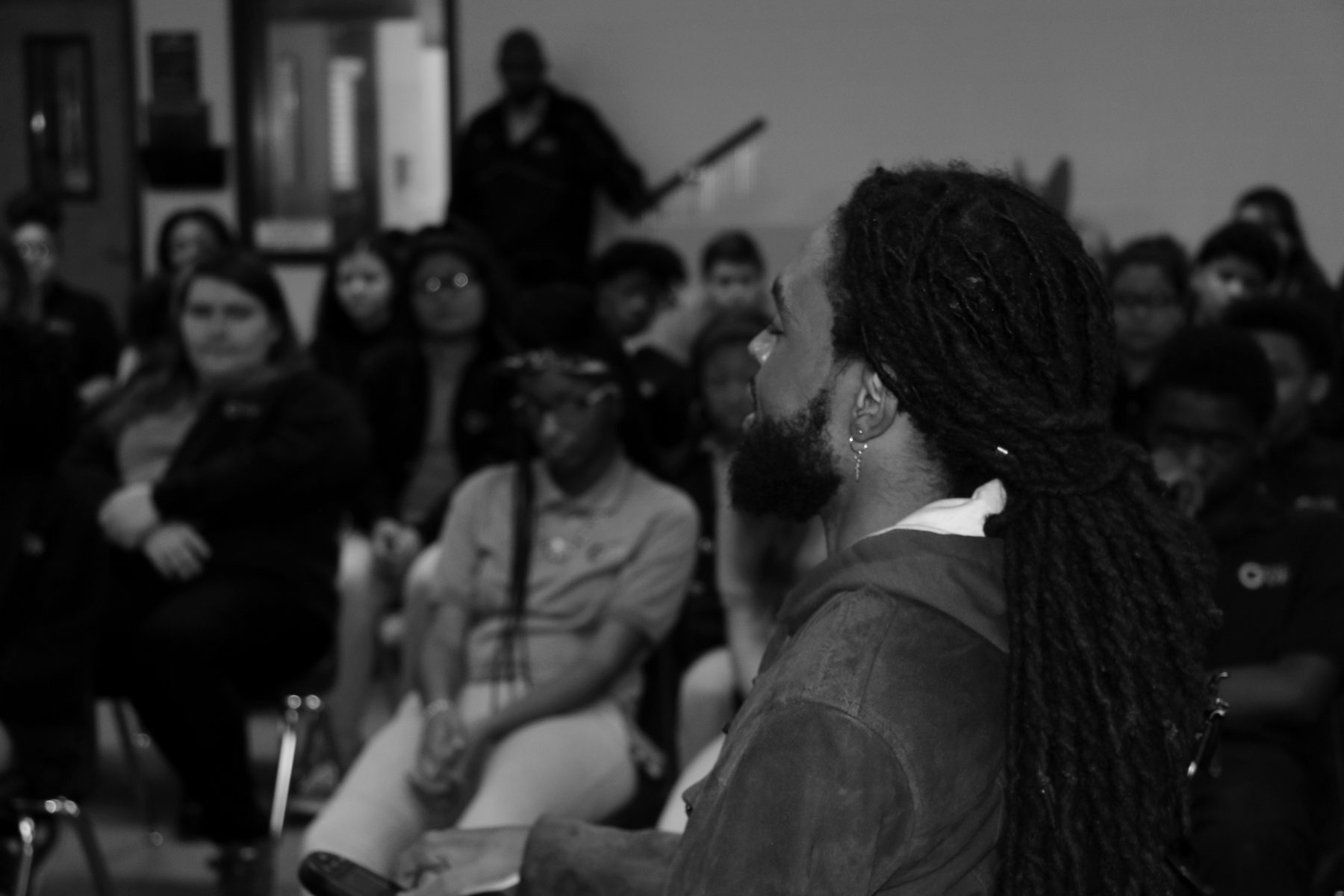 Que Crane speaking to a room of students